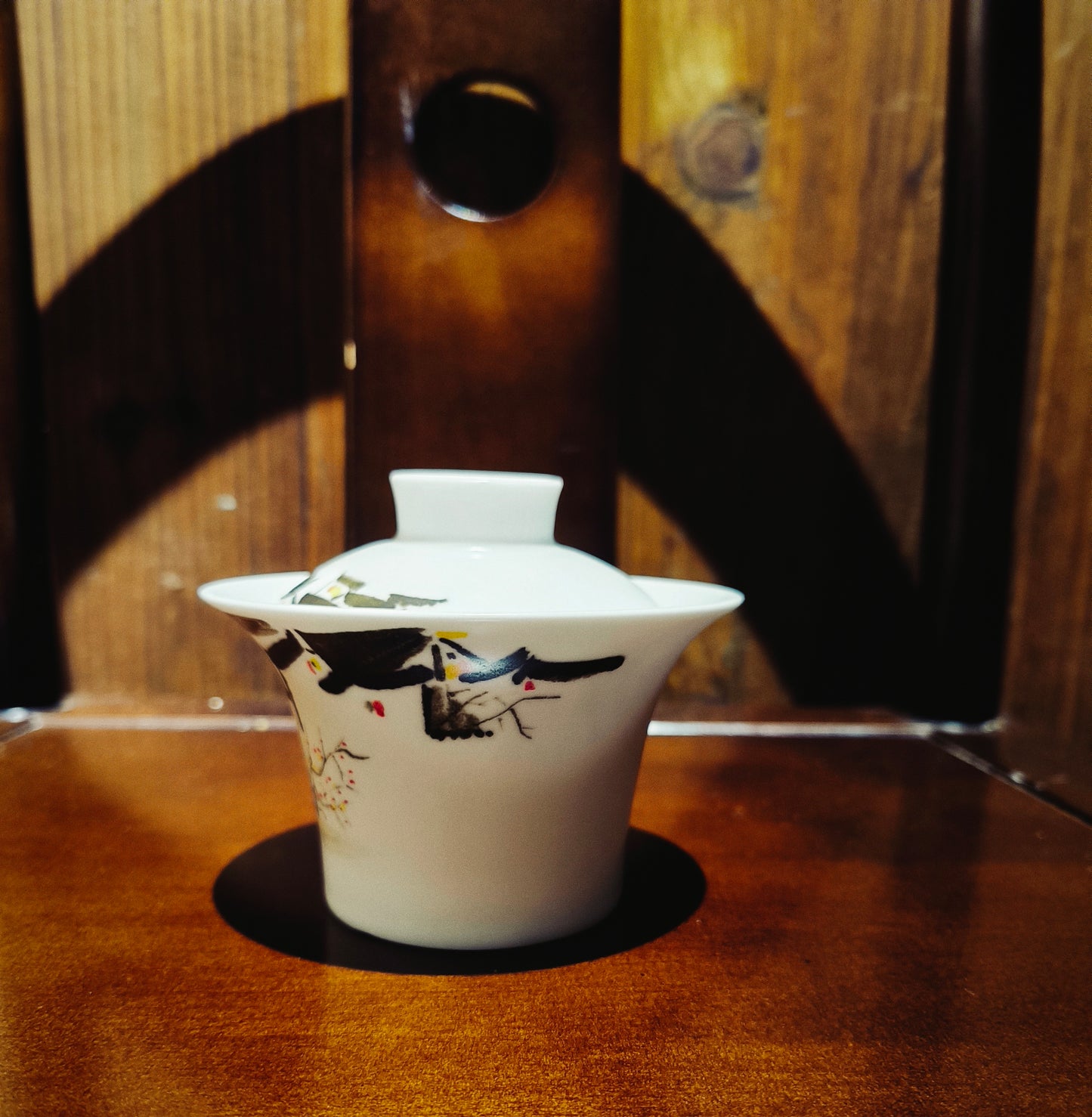 Handcrafted porcelain gaiwan with Wu Guanzhong inspired abstract painting, placed on a traditional Chinese oriental furniture