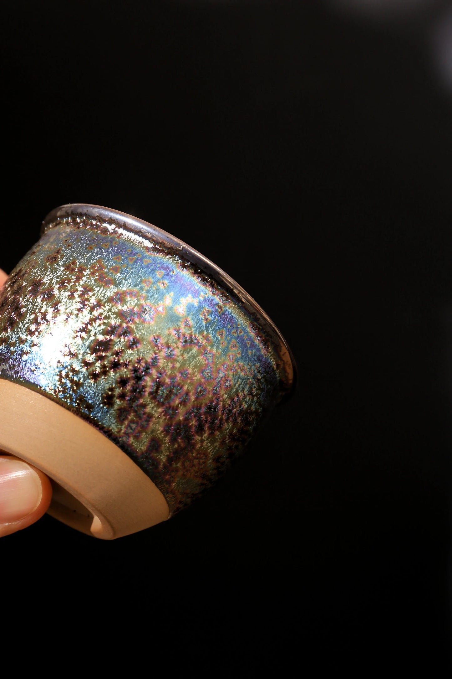 Rainbow Jian Zhan style ceramic tea cup close-up with iridescent glaze