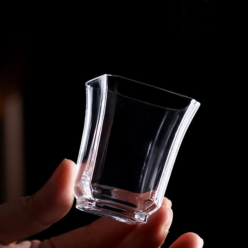 Hand holding Zen style borosilicate glass mini cup with tapered edges