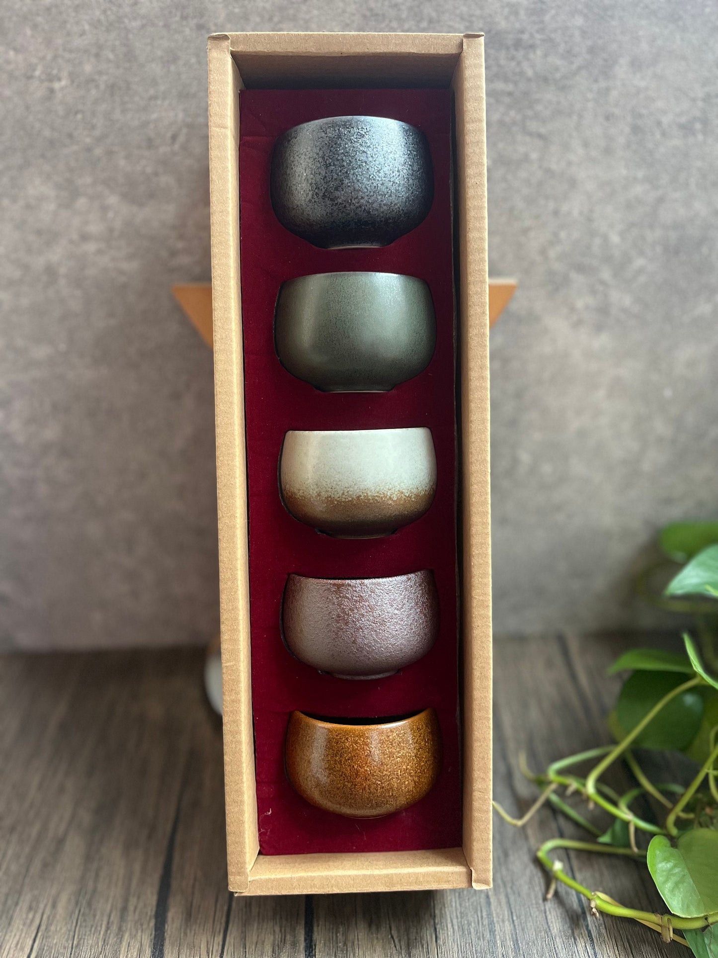 Top-down view of Taoist inspired ceramic tea cup set of five with gold, wood, water, fire, and soil tones.