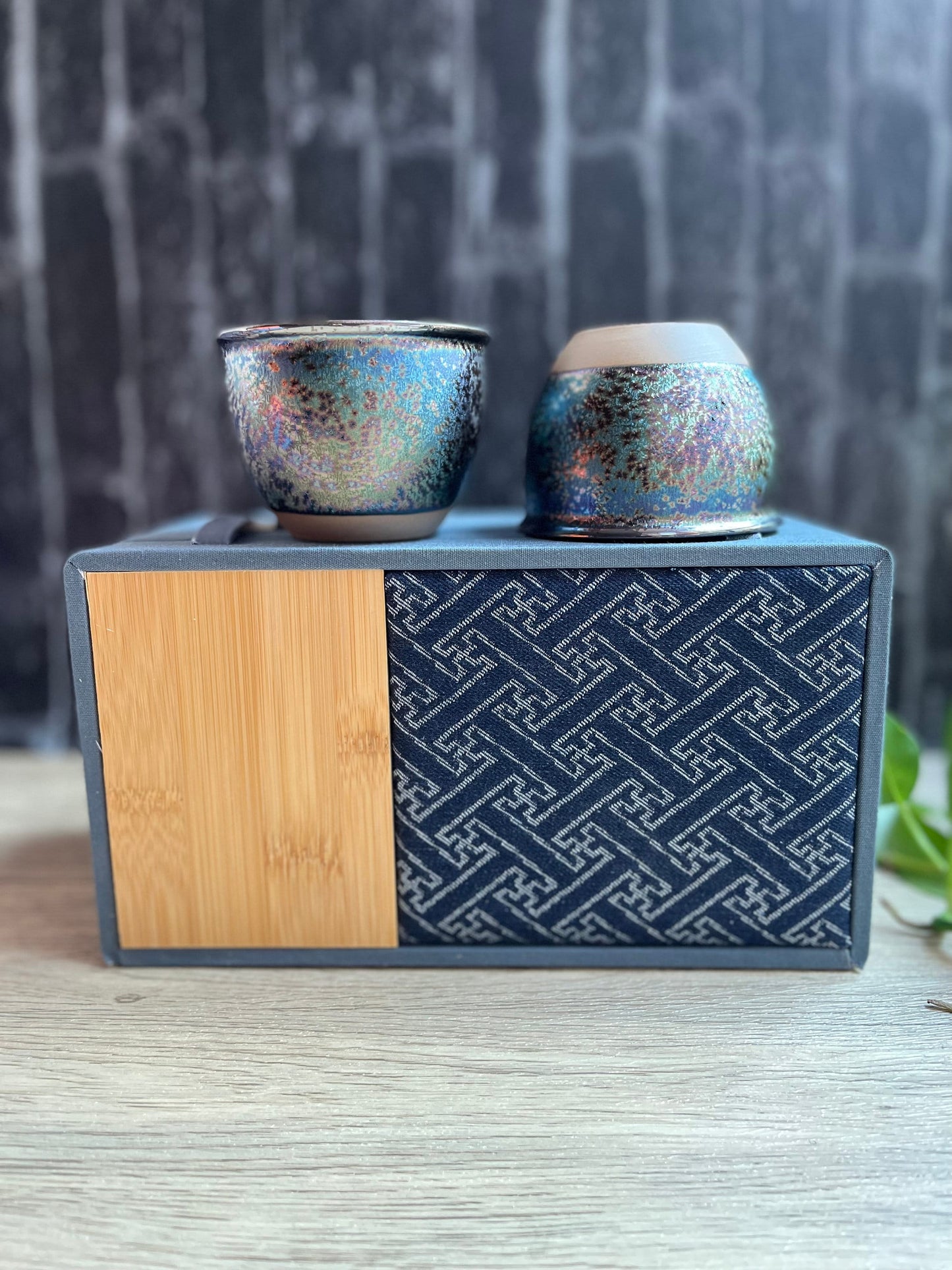 Two rainbow glazed ceramic cups displayed on top of bamboo and fabric gift box, made by Home Relax Studio.