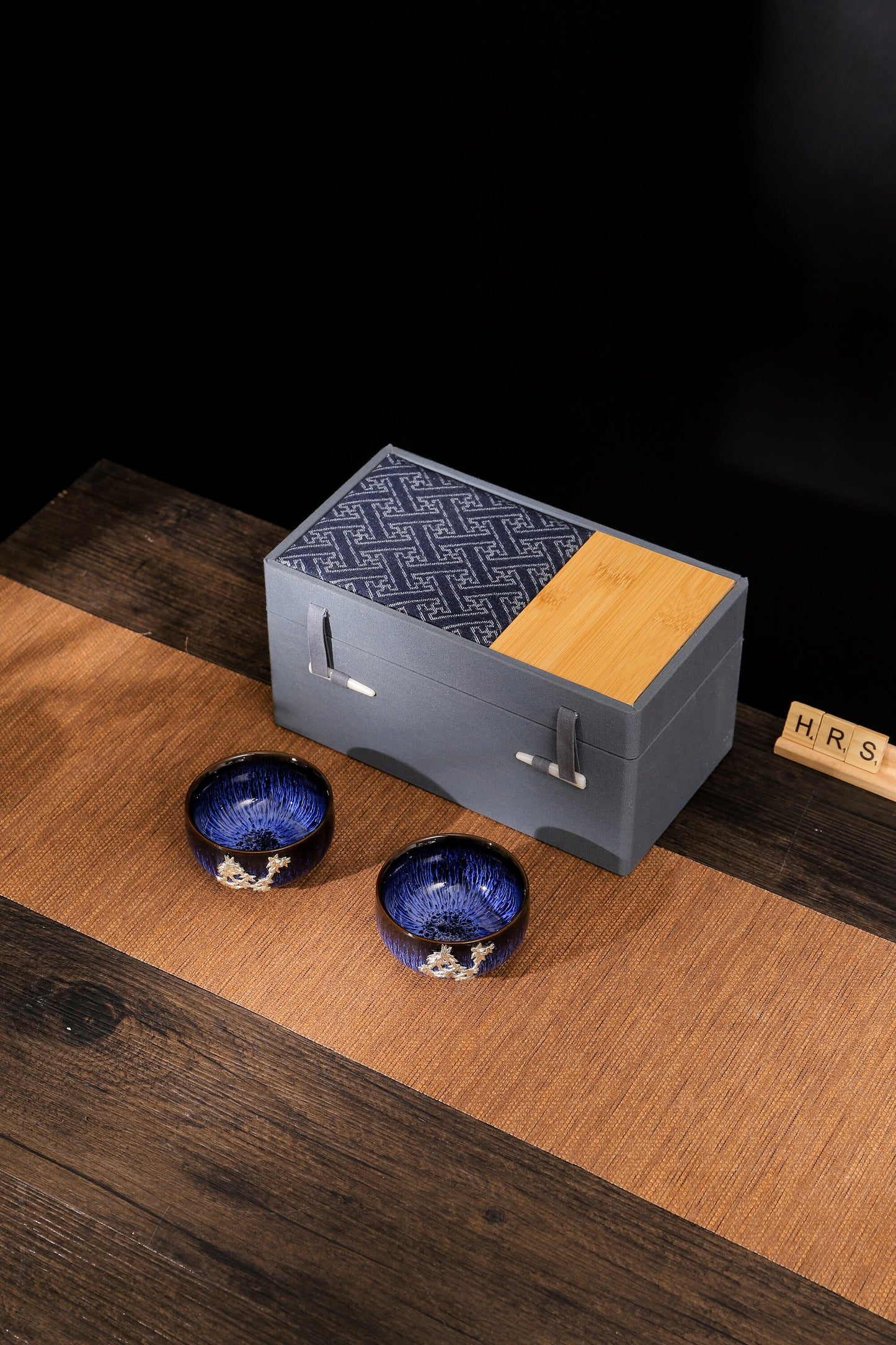 Blue Jian Zhan tea cups with maple leaf design, displayed with luxury bamboo fabric gift box