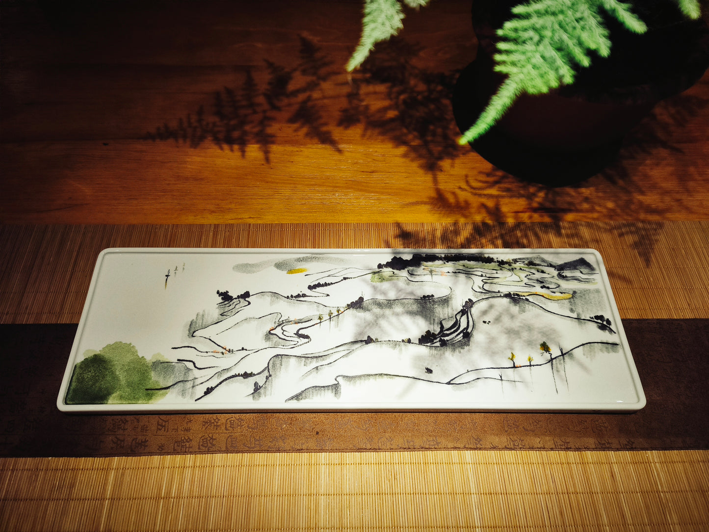 Close-up of artistic ceramic serving tray showcasing hand-painted brushwork inspired by Wu Guanzhong