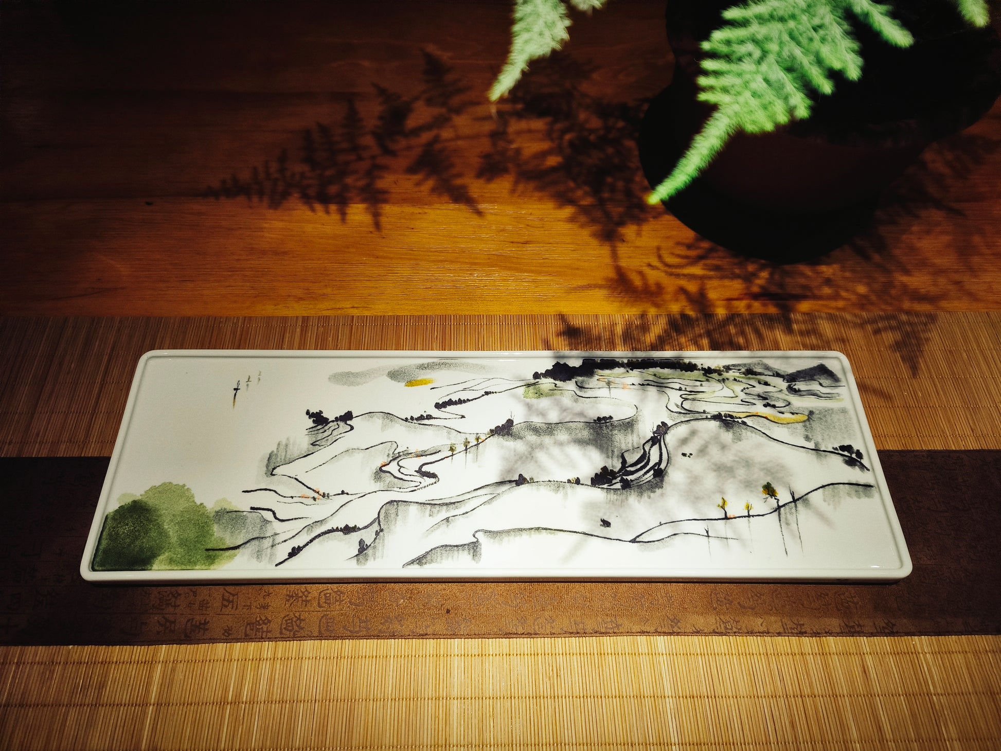 Close-up of artistic ceramic serving tray showcasing hand-painted brushwork inspired by Wu Guanzhong