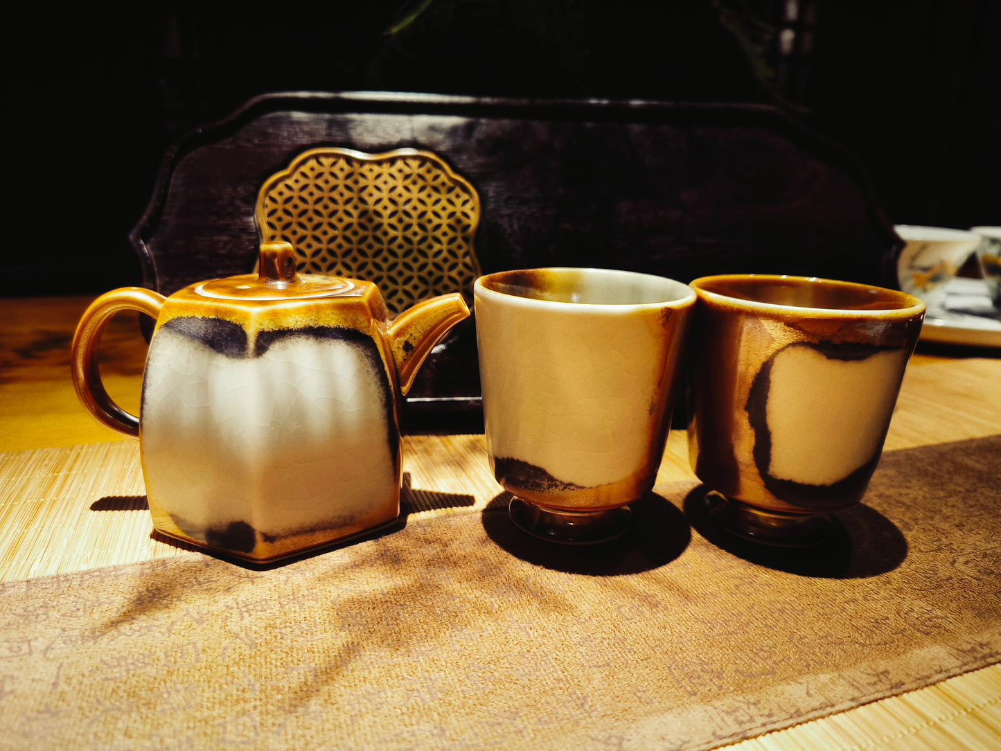 Complete ceramic tea set featuring vintage teapot, cups, and tray on wooden surface