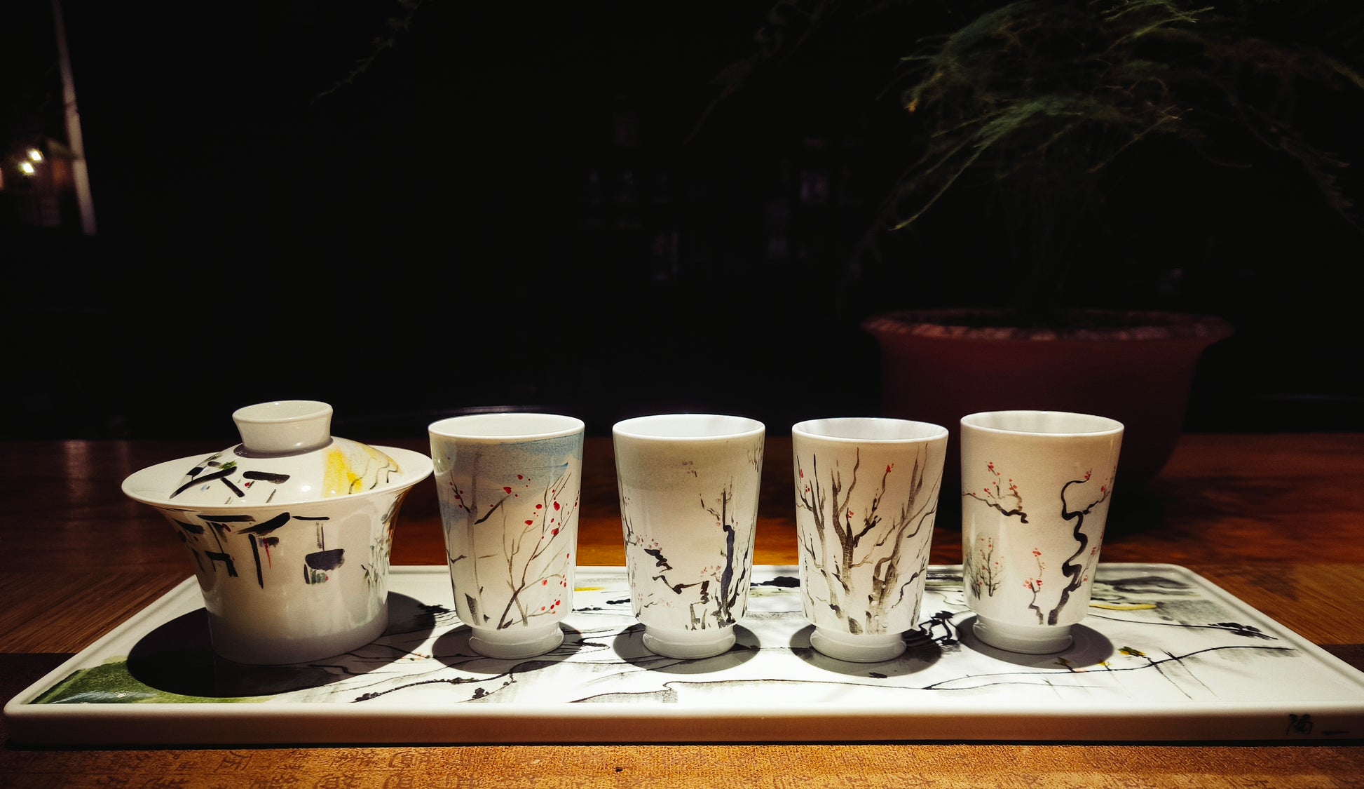 Complete porcelain tea set featuring tray, gaiwan, and four cups with abstract Chinese brushwork