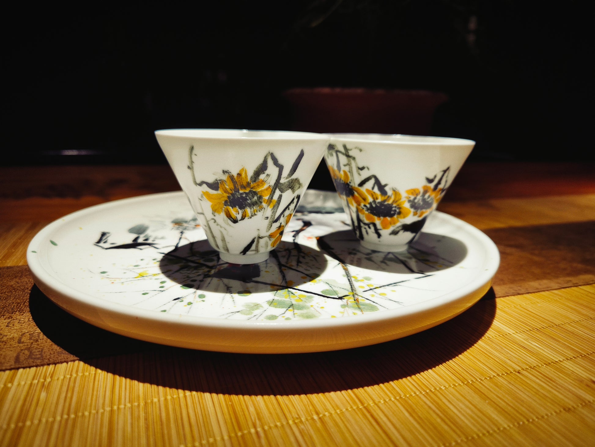 Detailed view of sunflower design on hand-painted ceramic plate and cups