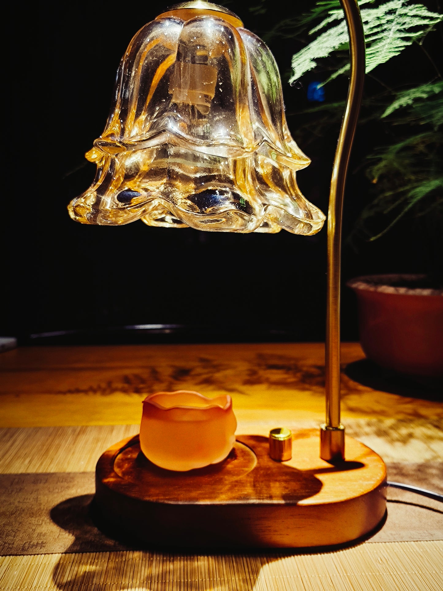 Fragrance warmer lamp with ceramic wax melt cup glowing under warm light