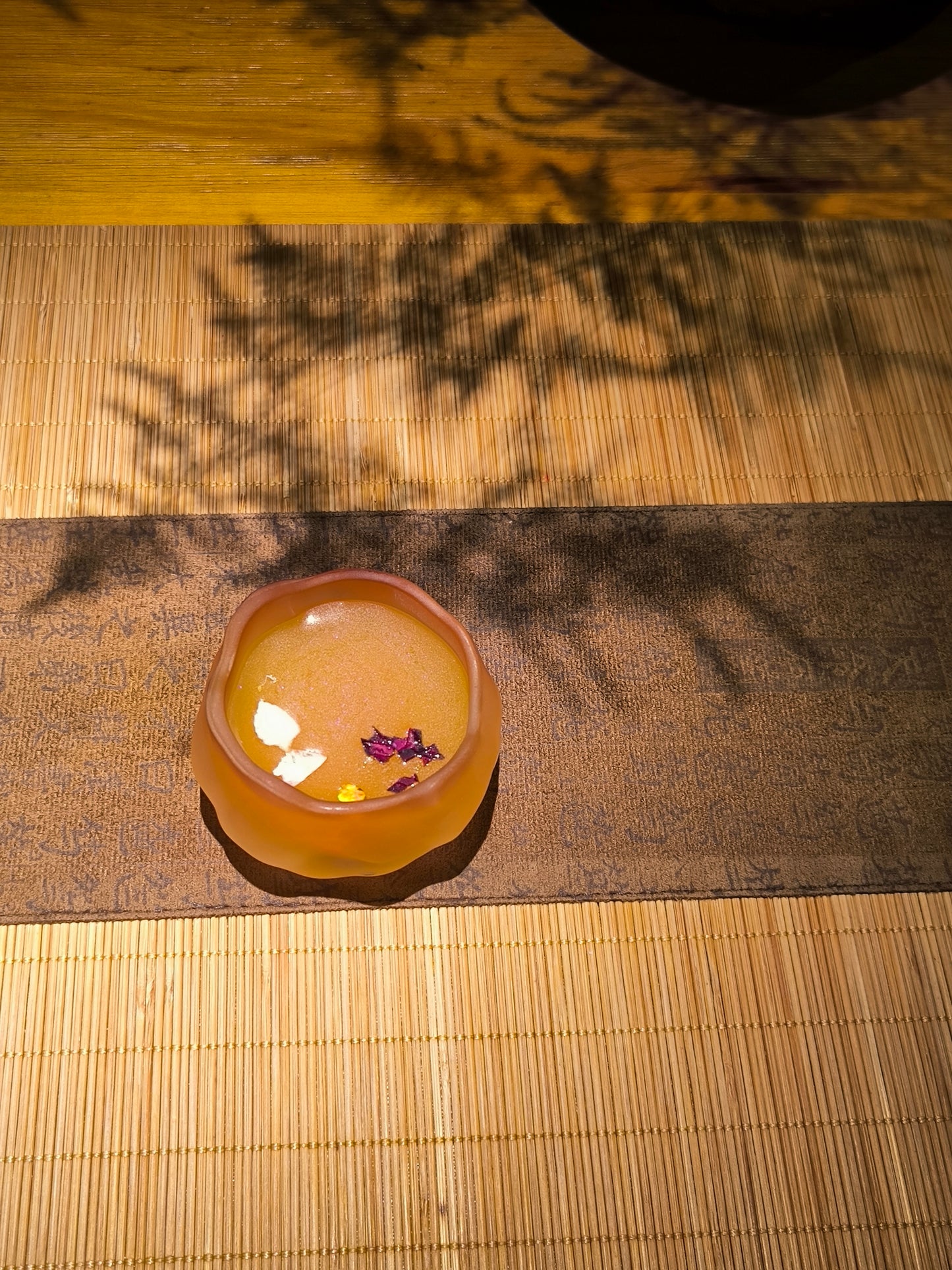 Handcrafted flower shaped ceramic wax melt cup infused with rose petals, displayed on elegant zen vibe table