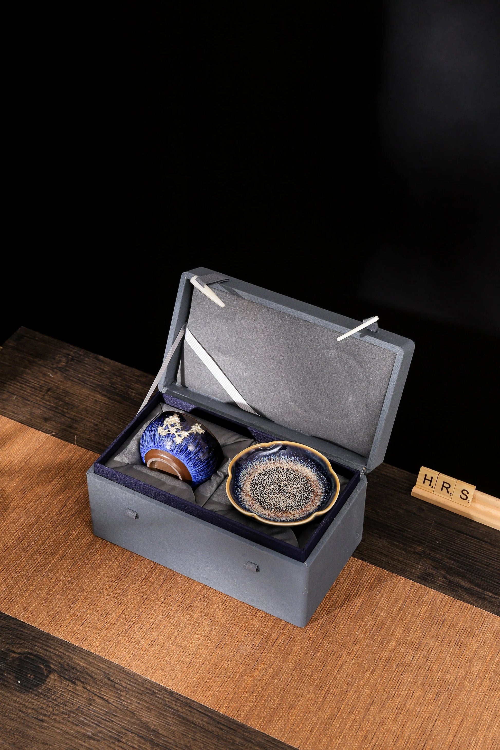 Open gift box showing Jian Zhan ceramic tea cup and Japanese style plate neatly packed – handmade drinkware se