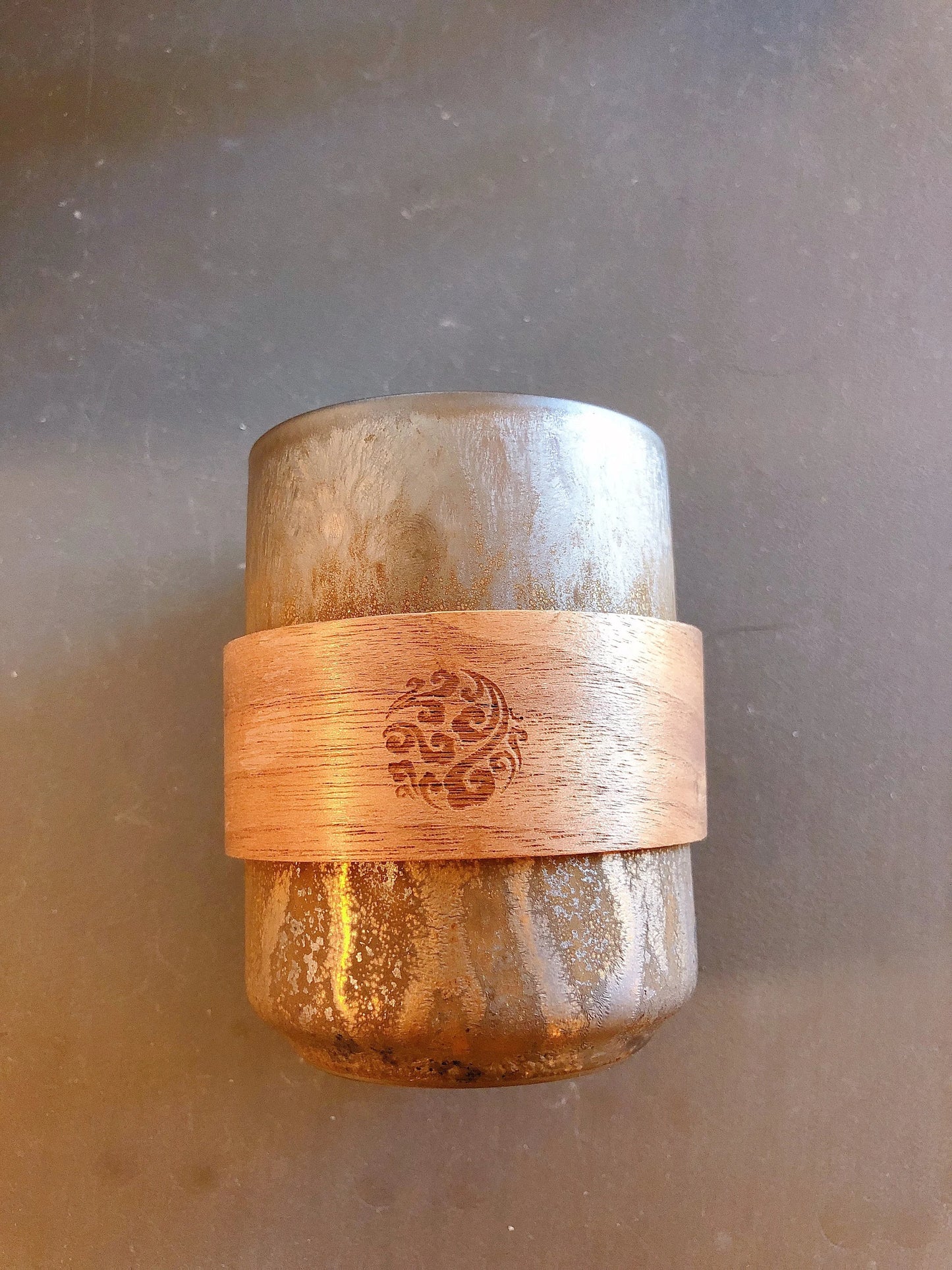 Rustic ceramic cup displayed with natural wood sleeve for safe handling and design addition 