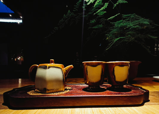 Vintage handmade ceramic tea set with teapot and two cups on a oriental style aesthetic wooden tray