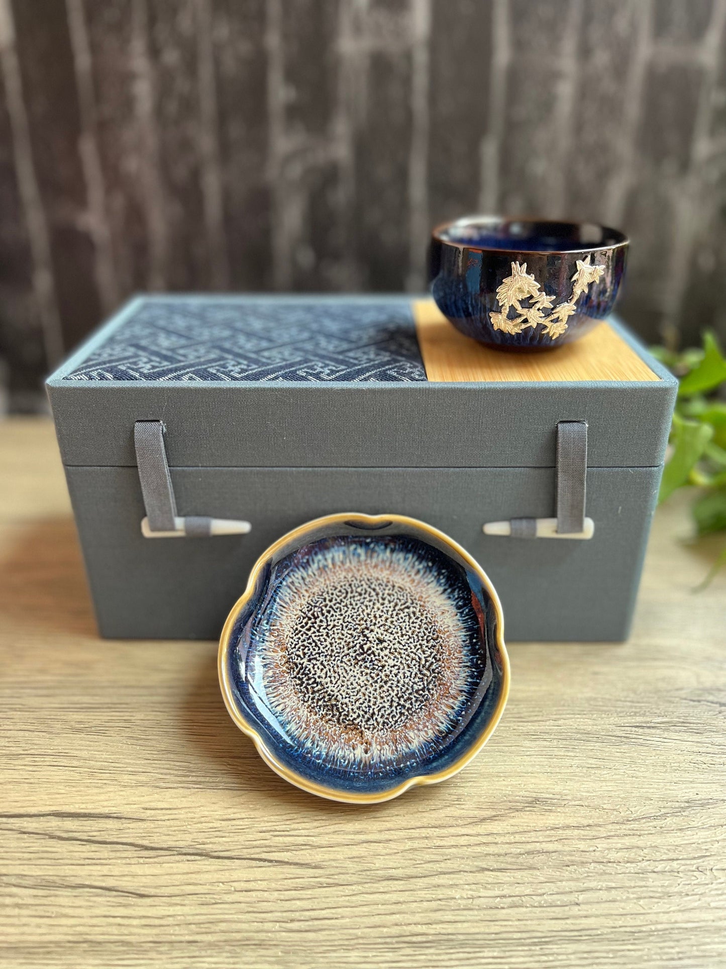 Blue floral tea cup and dish set elegantly placed on a decorative gift box.