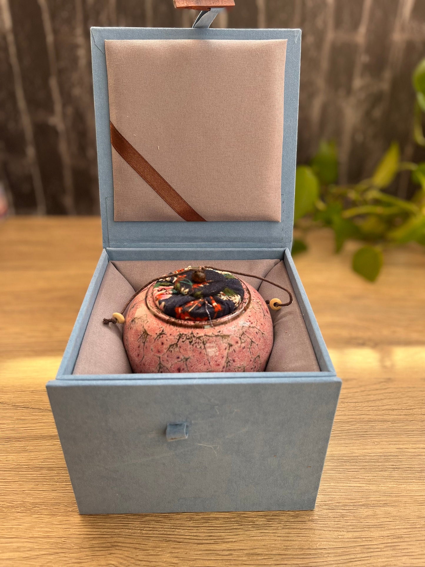 Ceramic gift set with tea storage jar packaged inside a blue gift box