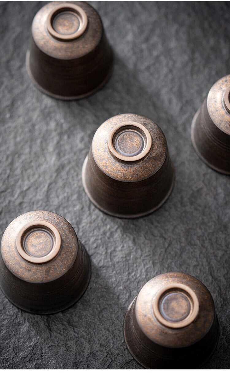 Close-up of artisan-crafted mini tea cup showing hand-pulled ceramic design and the bottom of the cups