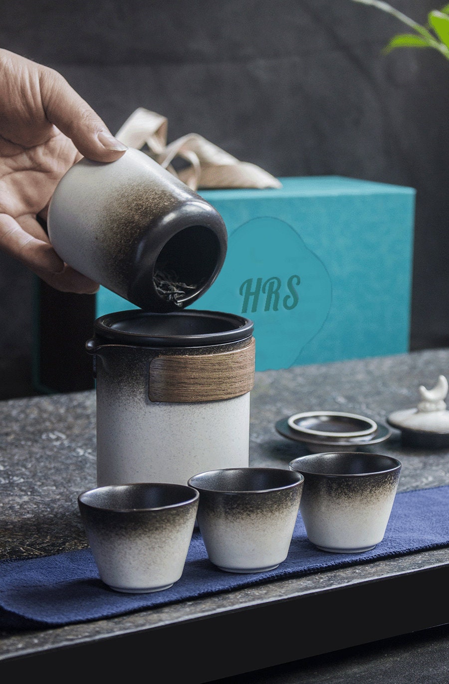 Complete travel tea set with kettle, cups, and storage jar arranged on tray_with gift packaging on the side