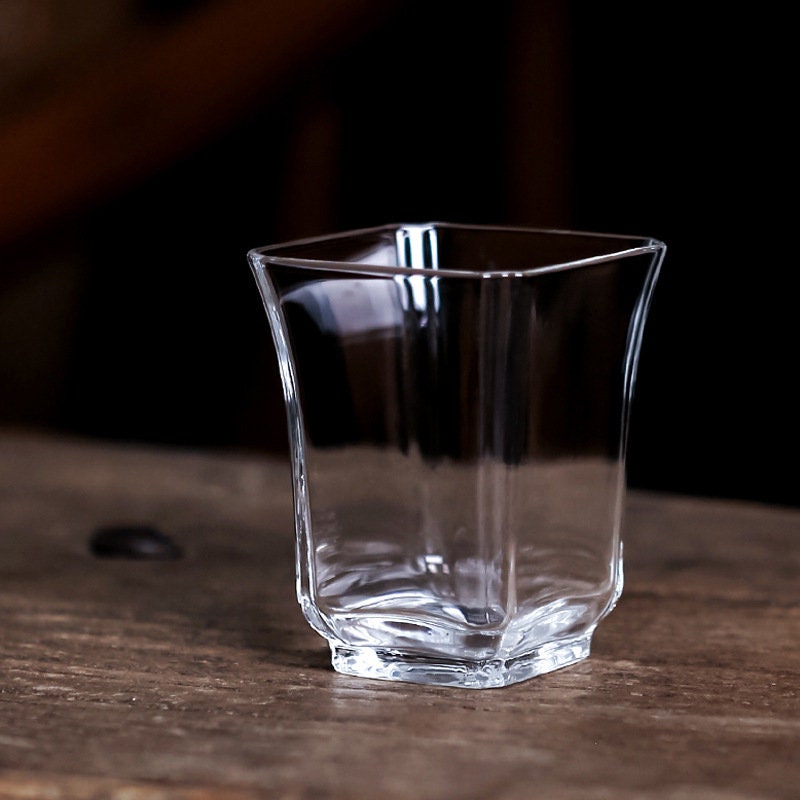 Empty clear borosilicate glass mini tea cup with faceted design on table