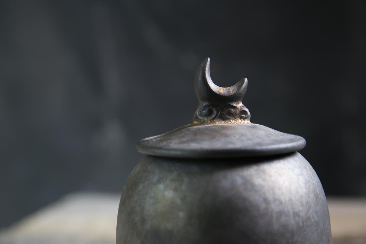 Handcrafted ceramic tea storage jar with moon lid detail – rustic tea canister