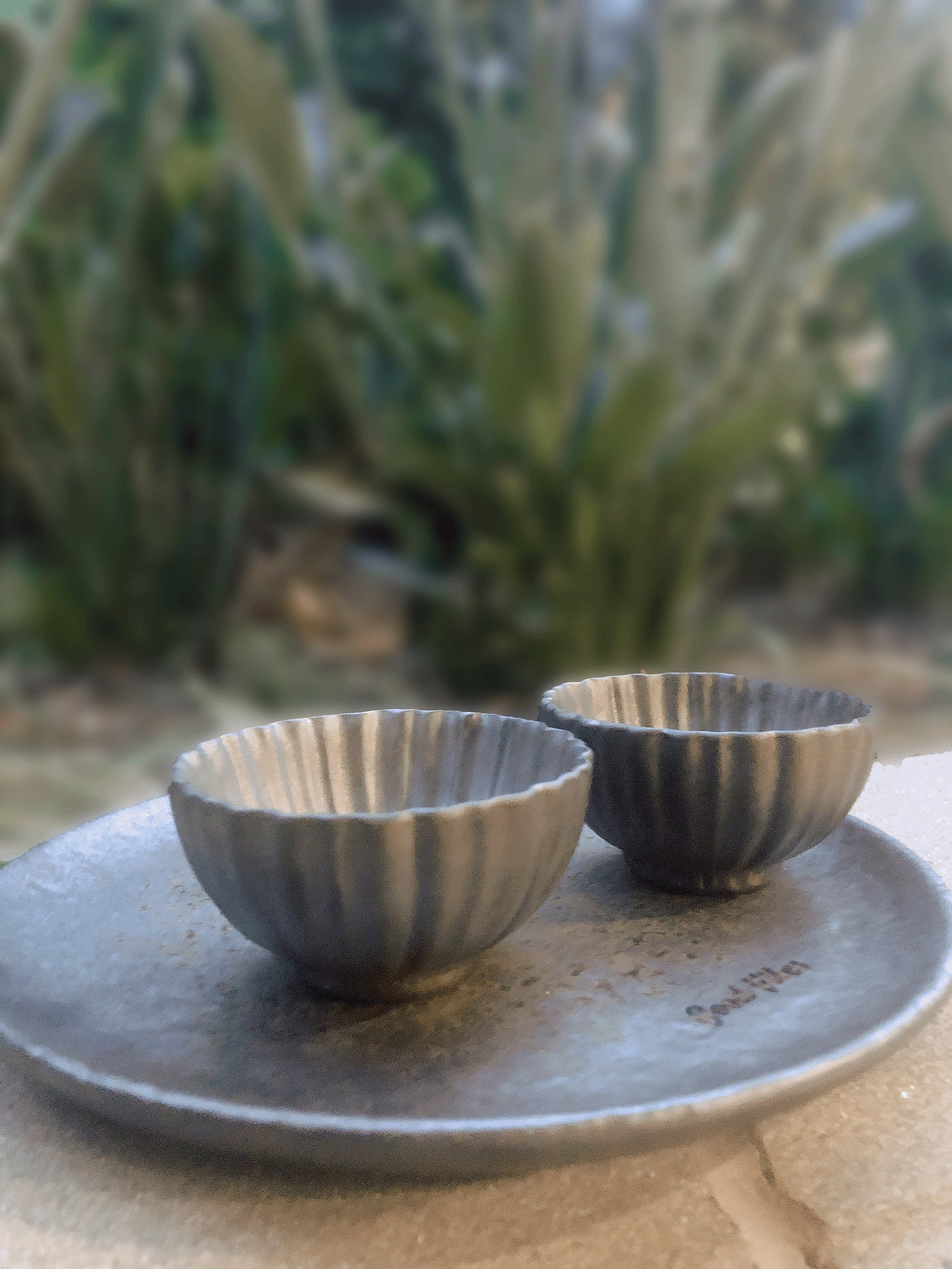 Handmade ceramic tea cups in flower petal shapes with a matching tray, rustic and minimalist design