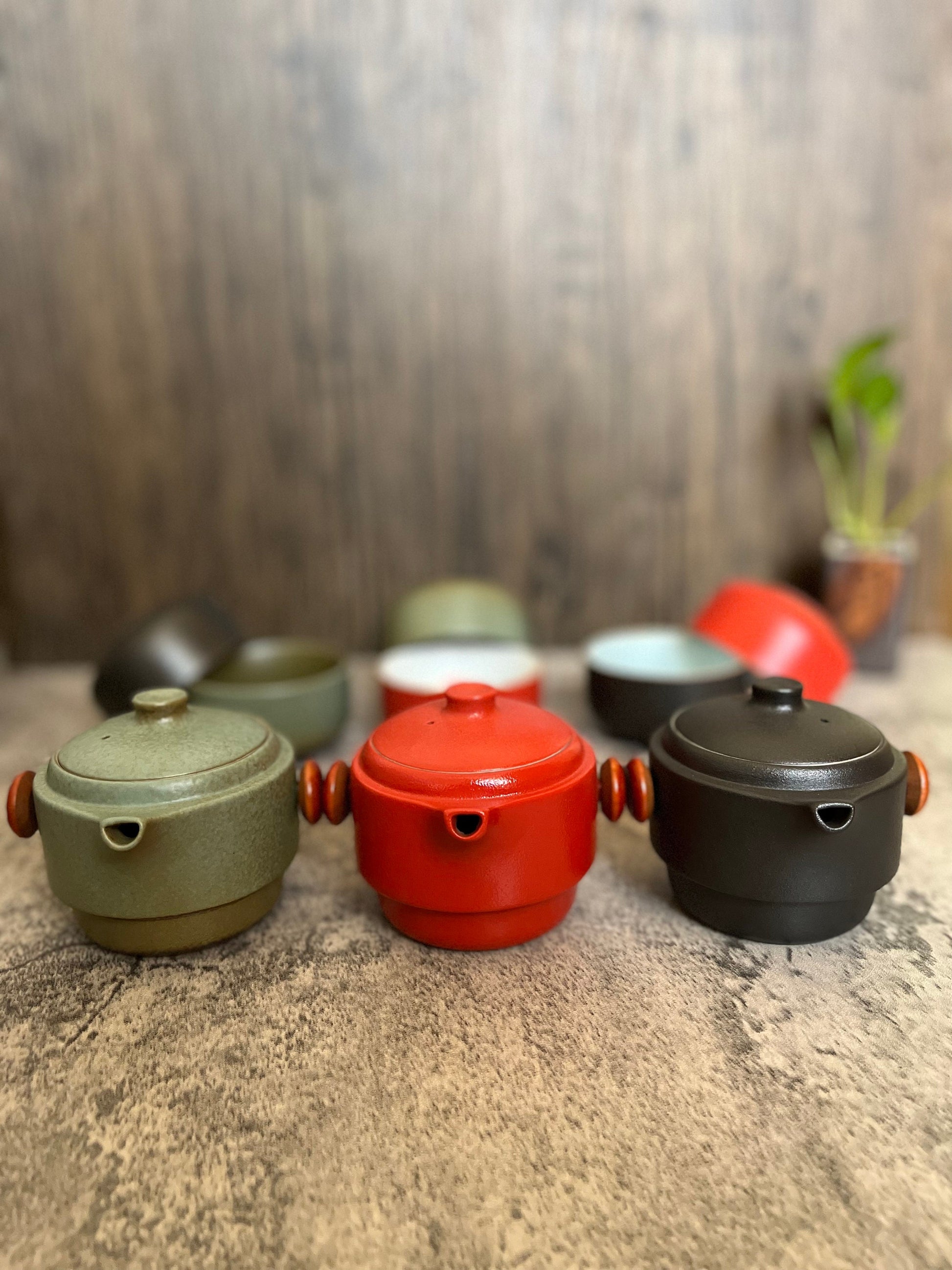 Handmade ceramic teapot and tea cup gift set for tea lovers_displaying the kettles part of the all-in-one set_with cups in  the background