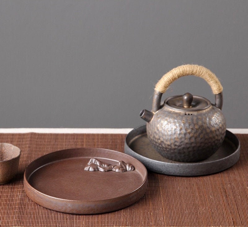 Japanese tea tray set featuring ceramic teapot, cups, and Zen-inspired plate.