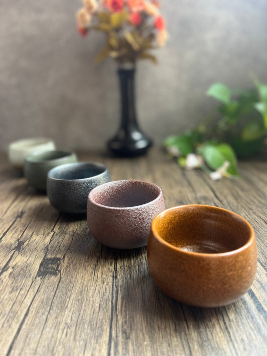Set of five Japanese ceramic tea cups in different elemental colors displayed on a wooden surface, made by Home Relax Studio.
