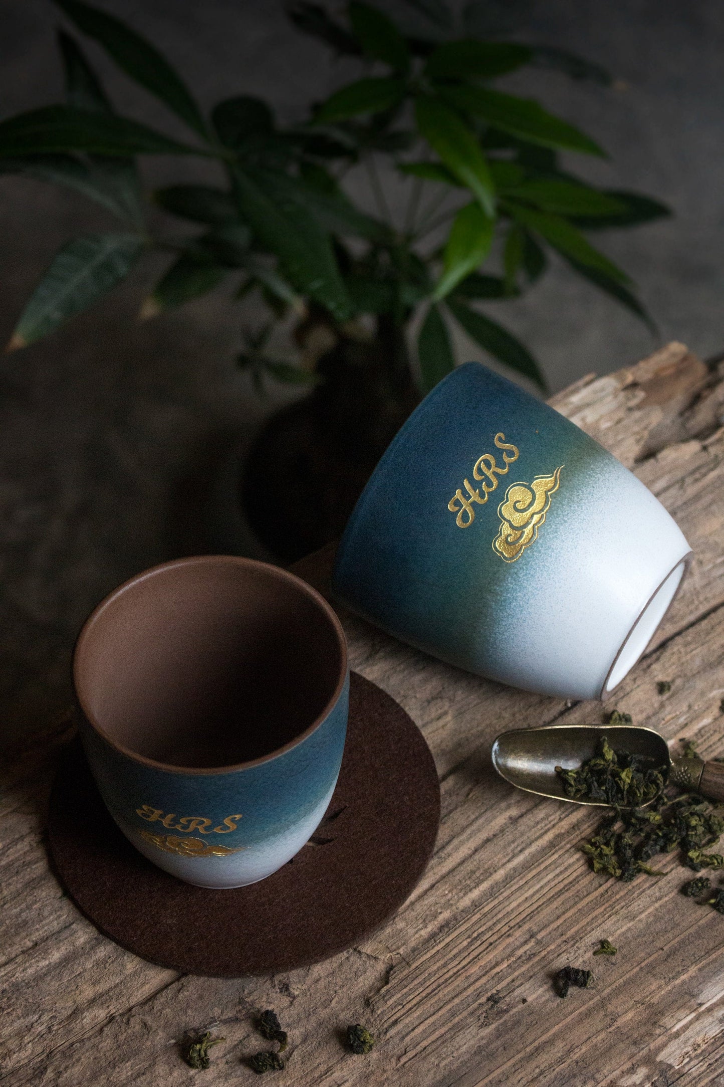 Two-toned retro ceramic tea cups displayed with tea leaves on table