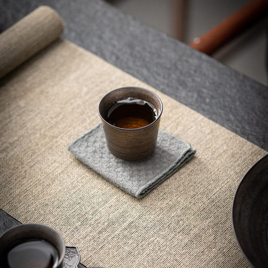 Vintage handmade ceramic mini tea cup with rustic finish on fabric mat