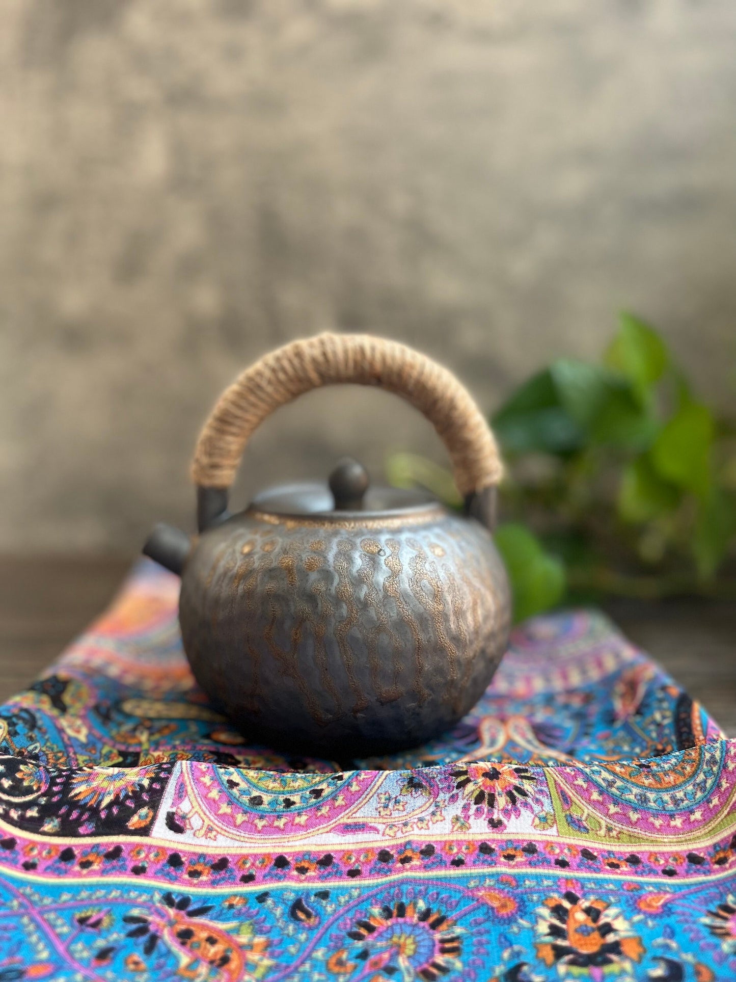 Zen-inspired ceramic teapot displayed with small white tea cups